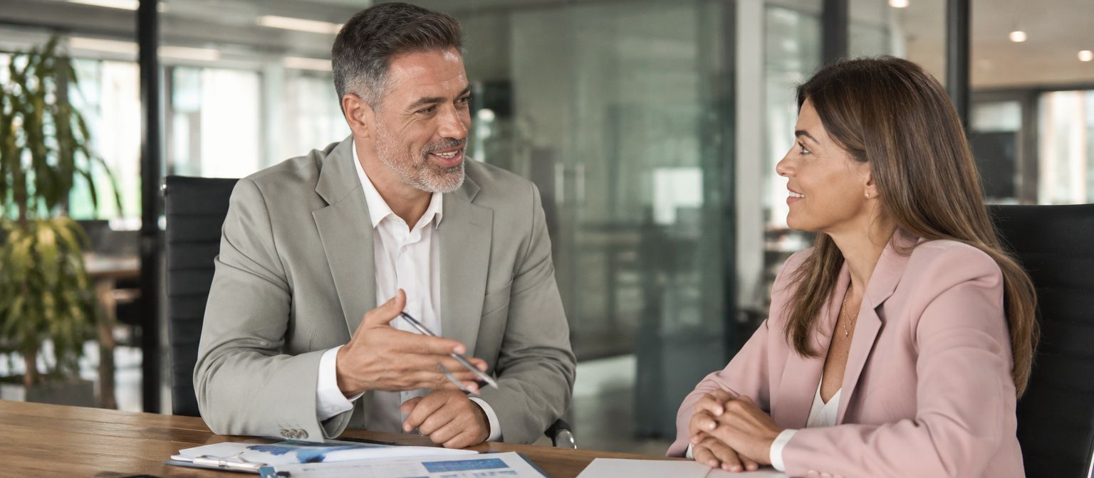 Advisors working through a transaction across a conference table